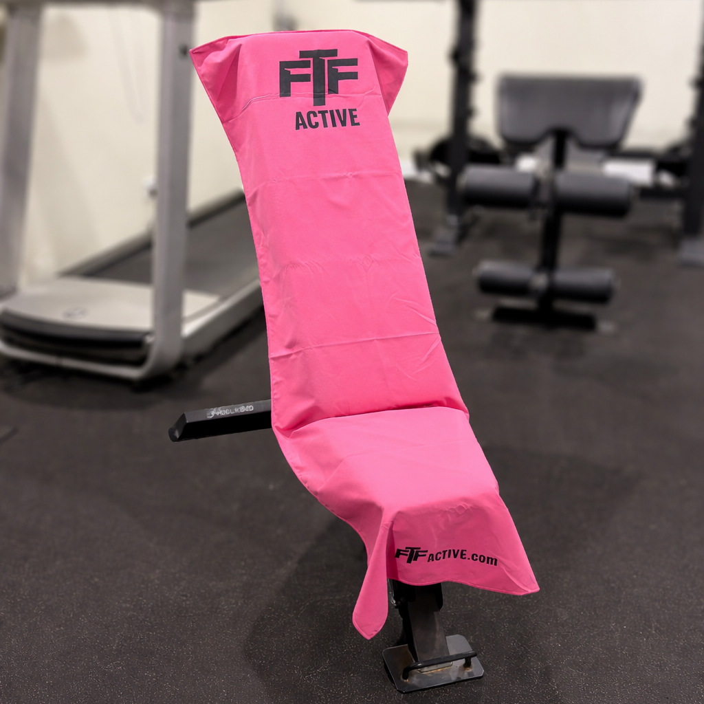 Pink BenchLock Hooded Gym Towel securely held in place on incline bench 