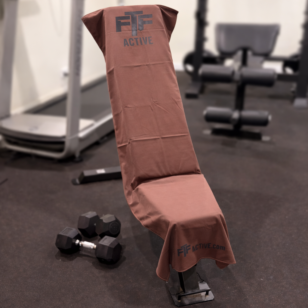 Brown BenchLock Hooded Gym Towel securely held in place on incline bench 