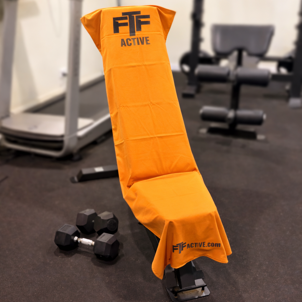 Orange BenchLock Hooded Gym Towel securely held in place on incline bench 